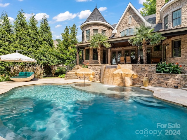 view of pool with exterior bar and a patio