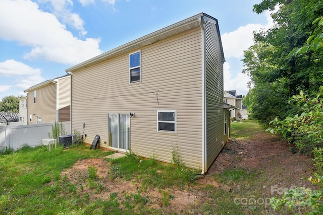 back of property featuring a yard and central air condition unit