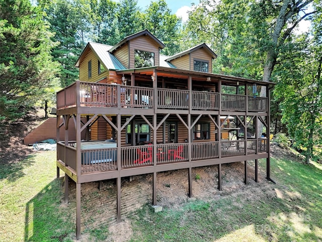 rear view of house with a deck and a yard