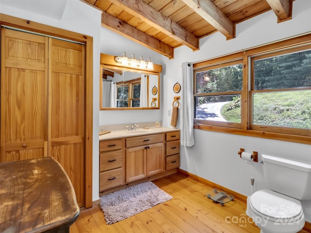 bathroom with hardwood / wood-style floors, vanity, vaulted ceiling with beams, toilet, and wooden ceiling