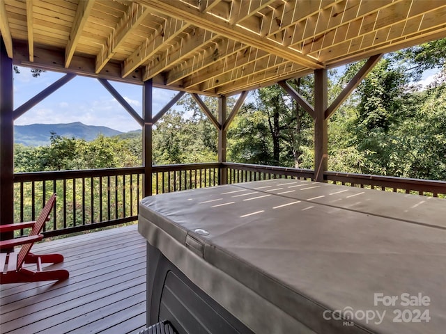 deck featuring a mountain view and a hot tub