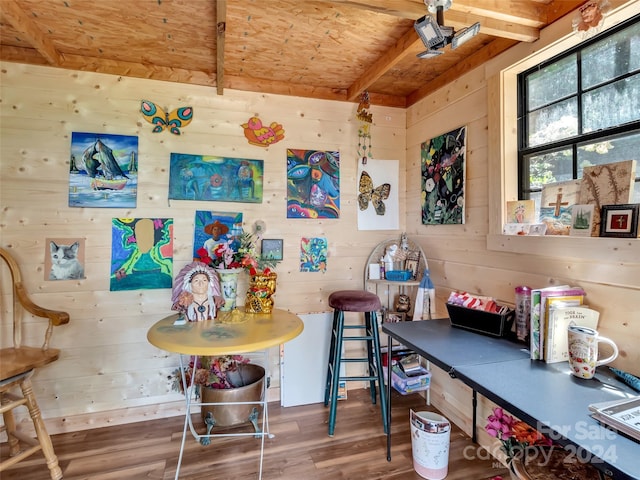 interior space with wood walls, wood ceiling, beam ceiling, and wood finished floors