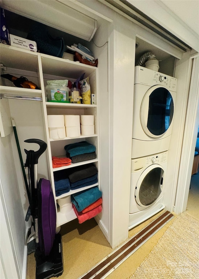 laundry area with carpet and stacked washer and clothes dryer