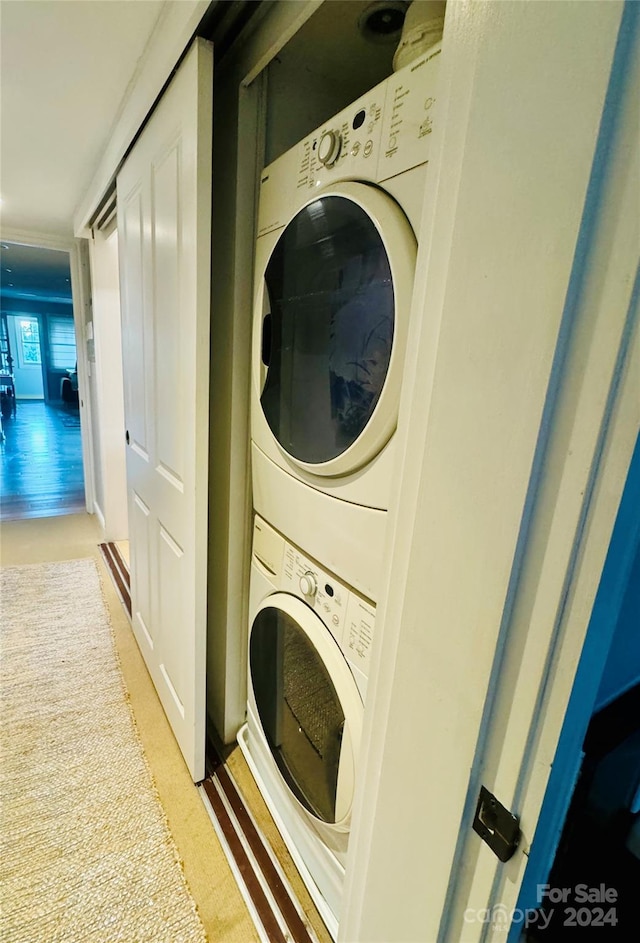 clothes washing area featuring stacked washing maching and dryer