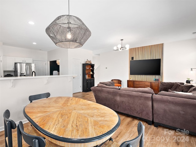 dining area with a chandelier and light hardwood / wood-style flooring