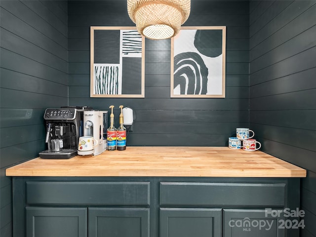 interior space featuring butcher block countertops, an inviting chandelier, and wooden walls