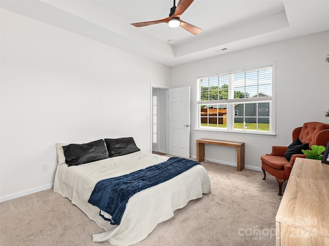 bedroom featuring ceiling fan, carpet flooring, and a raised ceiling