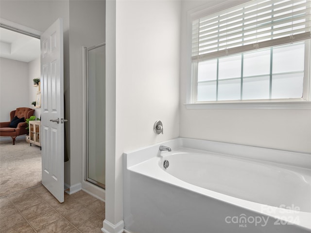 bathroom with separate shower and tub, tile patterned flooring, and a wealth of natural light