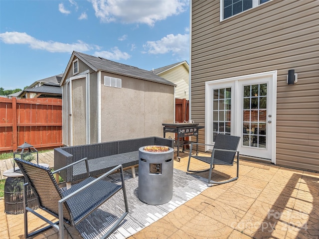 view of patio / terrace with a shed and an outdoor fire pit