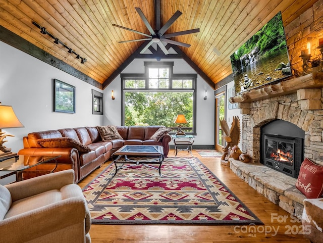 living room with rail lighting, wood ceiling, high vaulted ceiling, a fireplace, and hardwood / wood-style floors