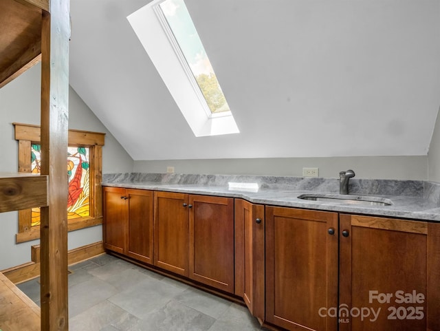 interior space featuring lofted ceiling with skylight and sink