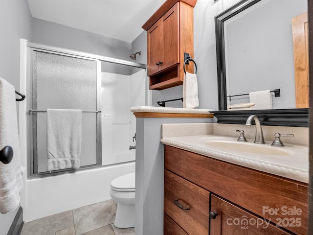 full bathroom with tile patterned flooring, toilet, combined bath / shower with glass door, and vanity