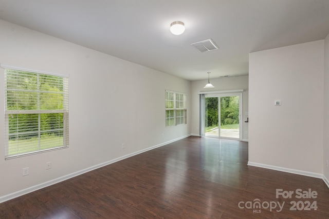 empty room with dark hardwood / wood-style flooring