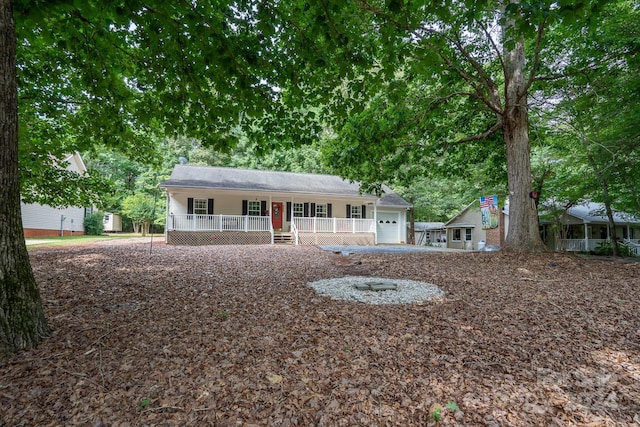 ranch-style home featuring covered porch and a garage