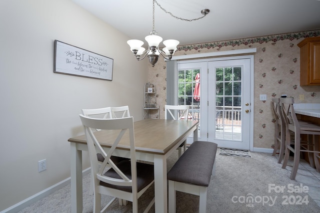 dining area featuring light carpet and an inviting chandelier