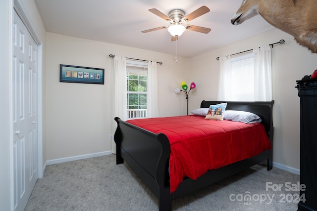 carpeted bedroom featuring ceiling fan and a closet