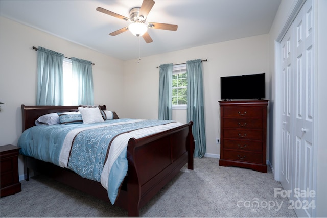 carpeted bedroom featuring ceiling fan and a closet