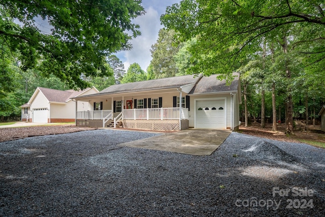 single story home featuring covered porch and a garage