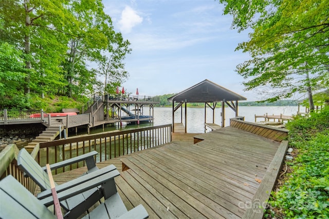 wooden deck with a boat dock and a water view