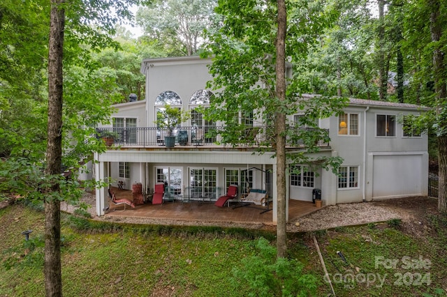 rear view of property with a deck and a patio area