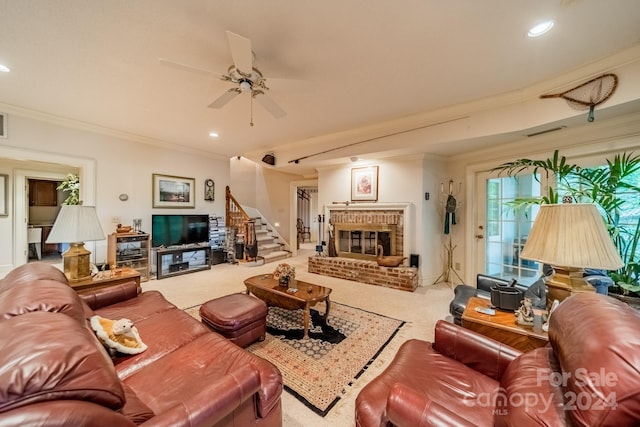 carpeted living room featuring ornamental molding, a brick fireplace, and ceiling fan