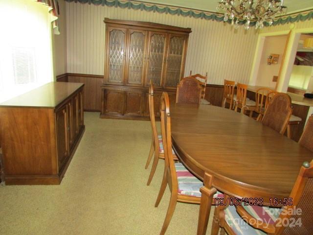 dining room featuring light colored carpet and a notable chandelier