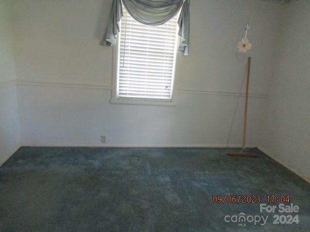 empty room featuring dark colored carpet