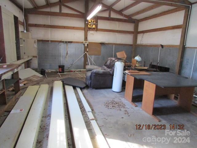 misc room with lofted ceiling and concrete flooring