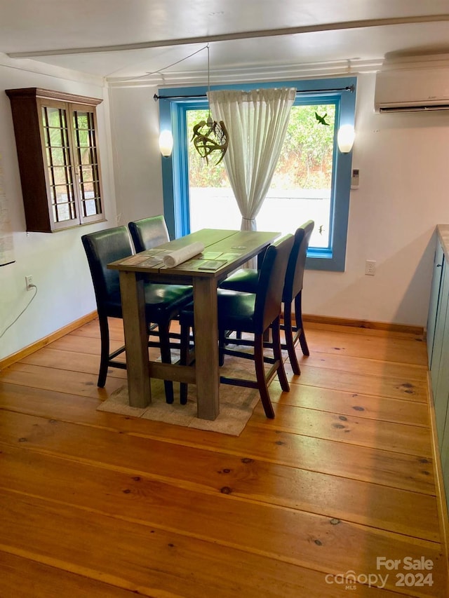 dining space with light hardwood / wood-style floors and a wall mounted air conditioner