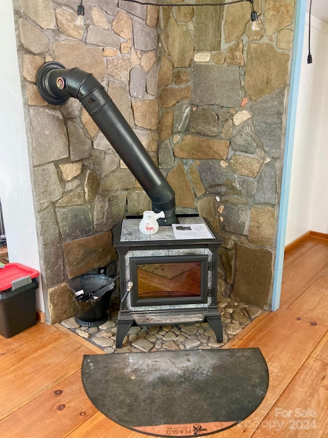 room details with a wood stove and hardwood / wood-style floors