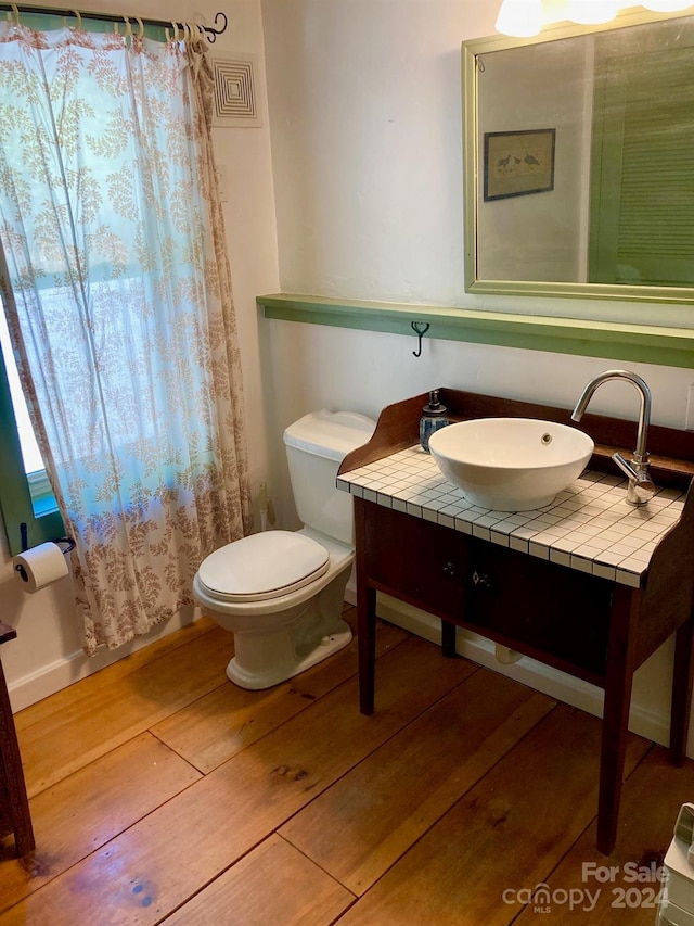 bathroom with sink, hardwood / wood-style floors, and toilet