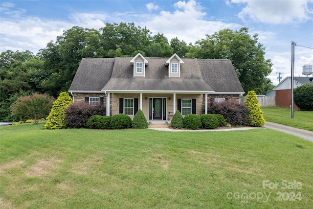 new england style home featuring a front yard