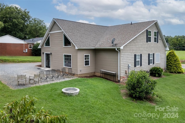 back of house with a yard, a patio, and an outdoor fire pit