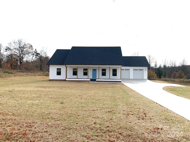 view of front facade featuring a porch, a garage, and a front lawn