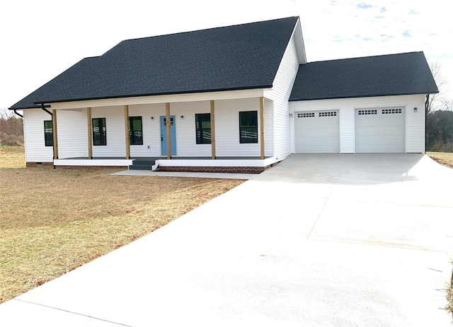 view of front of property featuring a porch, a garage, and a front lawn