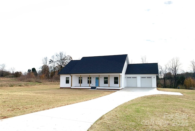 view of front of home featuring a front lawn, a porch, and a garage