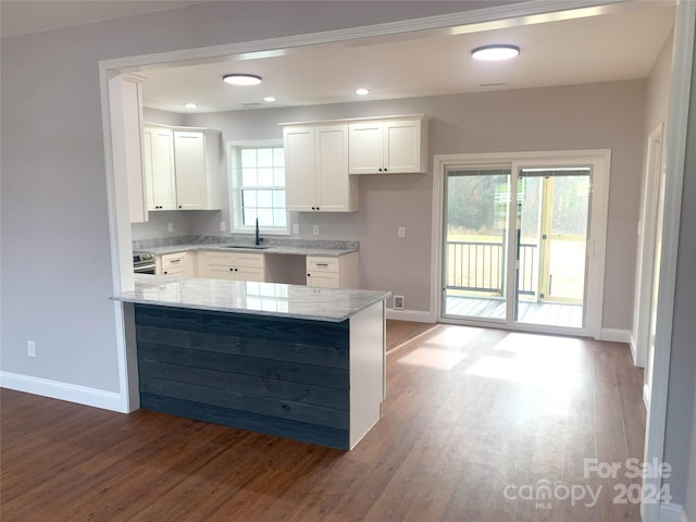 kitchen with white cabinets, a healthy amount of sunlight, dark hardwood / wood-style flooring, and sink