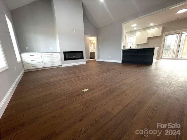 unfurnished living room featuring dark hardwood / wood-style floors and high vaulted ceiling