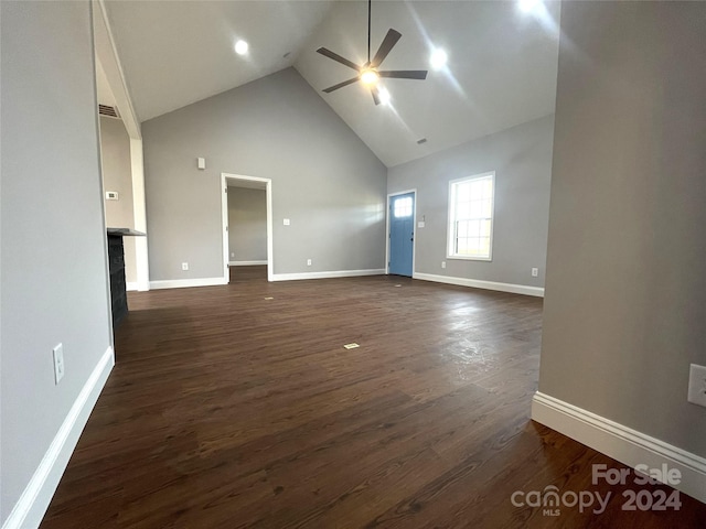 unfurnished living room with ceiling fan, high vaulted ceiling, and dark wood-type flooring