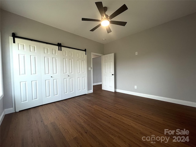 unfurnished bedroom with ceiling fan, dark hardwood / wood-style floors, and a closet