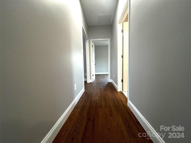 corridor with dark hardwood / wood-style flooring