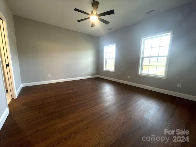 empty room with dark hardwood / wood-style floors and ceiling fan