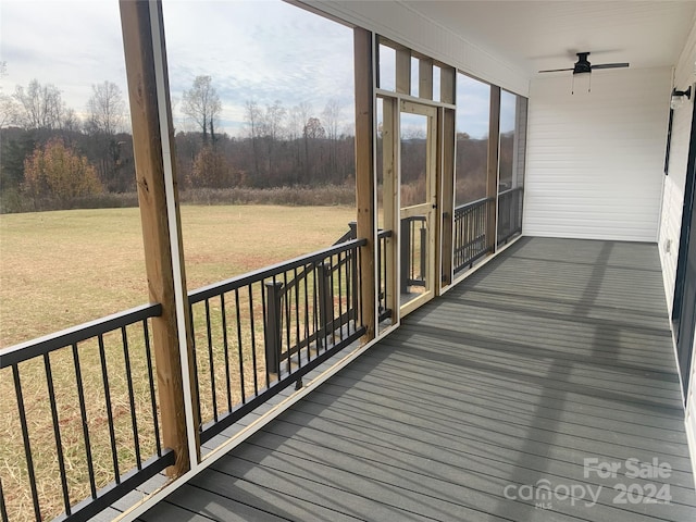 unfurnished sunroom with ceiling fan