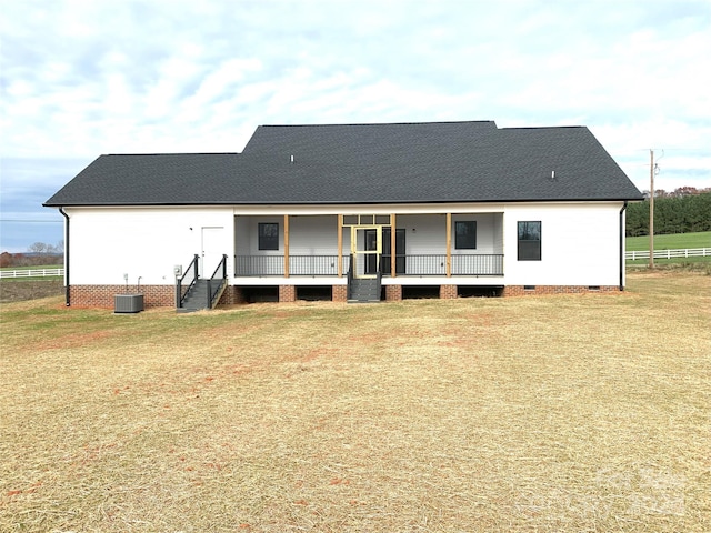 back of property featuring covered porch, a yard, and central AC