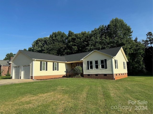 ranch-style house with a garage and a front lawn