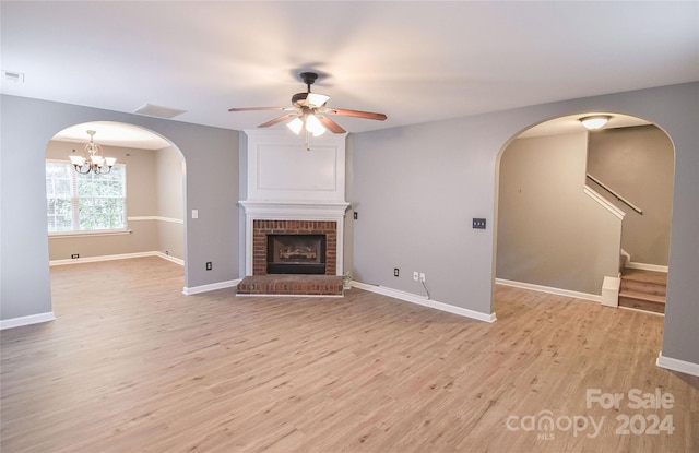 unfurnished living room featuring light hardwood / wood-style floors, ceiling fan, and a fireplace