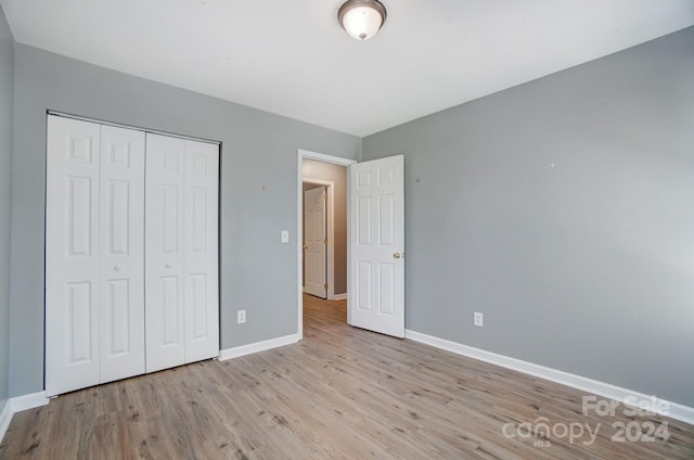 unfurnished bedroom with a closet and light wood-type flooring