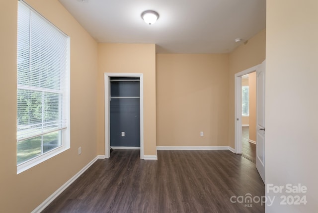 unfurnished bedroom with a closet and dark hardwood / wood-style flooring