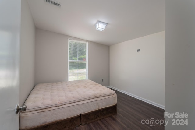 bedroom with vaulted ceiling and dark wood-type flooring