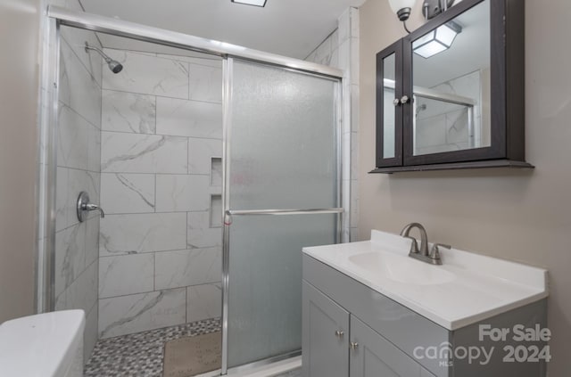 bathroom featuring vanity and a shower with door